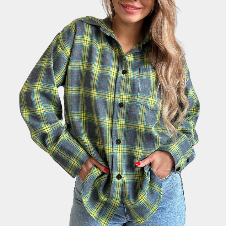 Vrouw in oversized geruite blouse met roze en grijze tinten, gecombineerd met zwarte broek. Modieuze dameskleding, casual stijl.